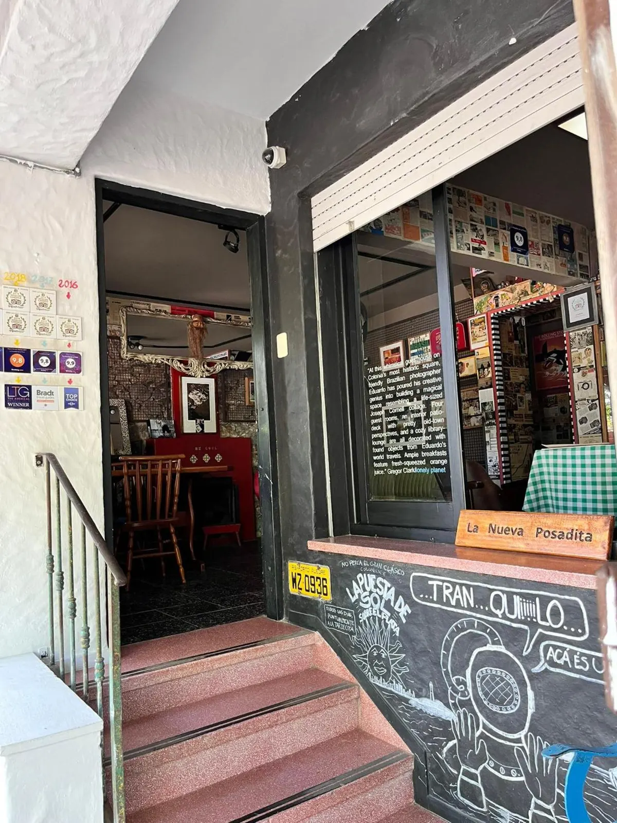 Entrada de La Nueva Posadita con el pizarrón y el cartel de madera